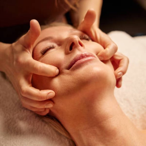 Mature Woman Relaxing During Face Massage in a Spa