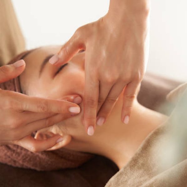 Japanese woman receiving a facial massage at an aesthetic salon
